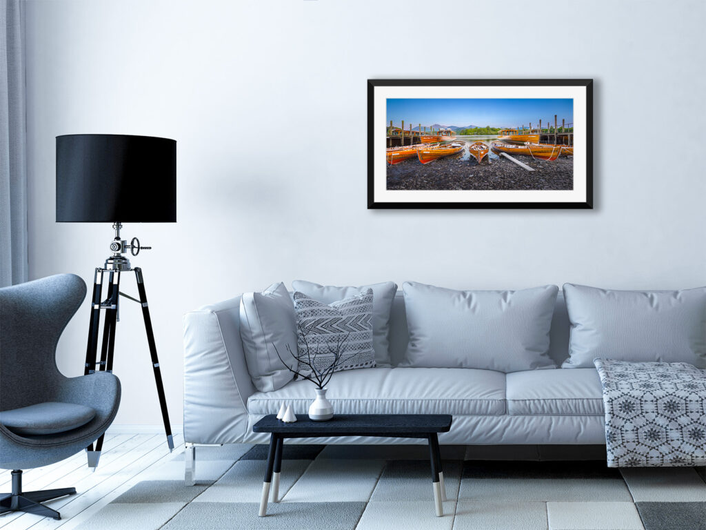 Wooden rowing boats at the Keswick Boat Landings, Derwentwater, Lake District. Shown here as a framed print mounted on a modern lounge wall.